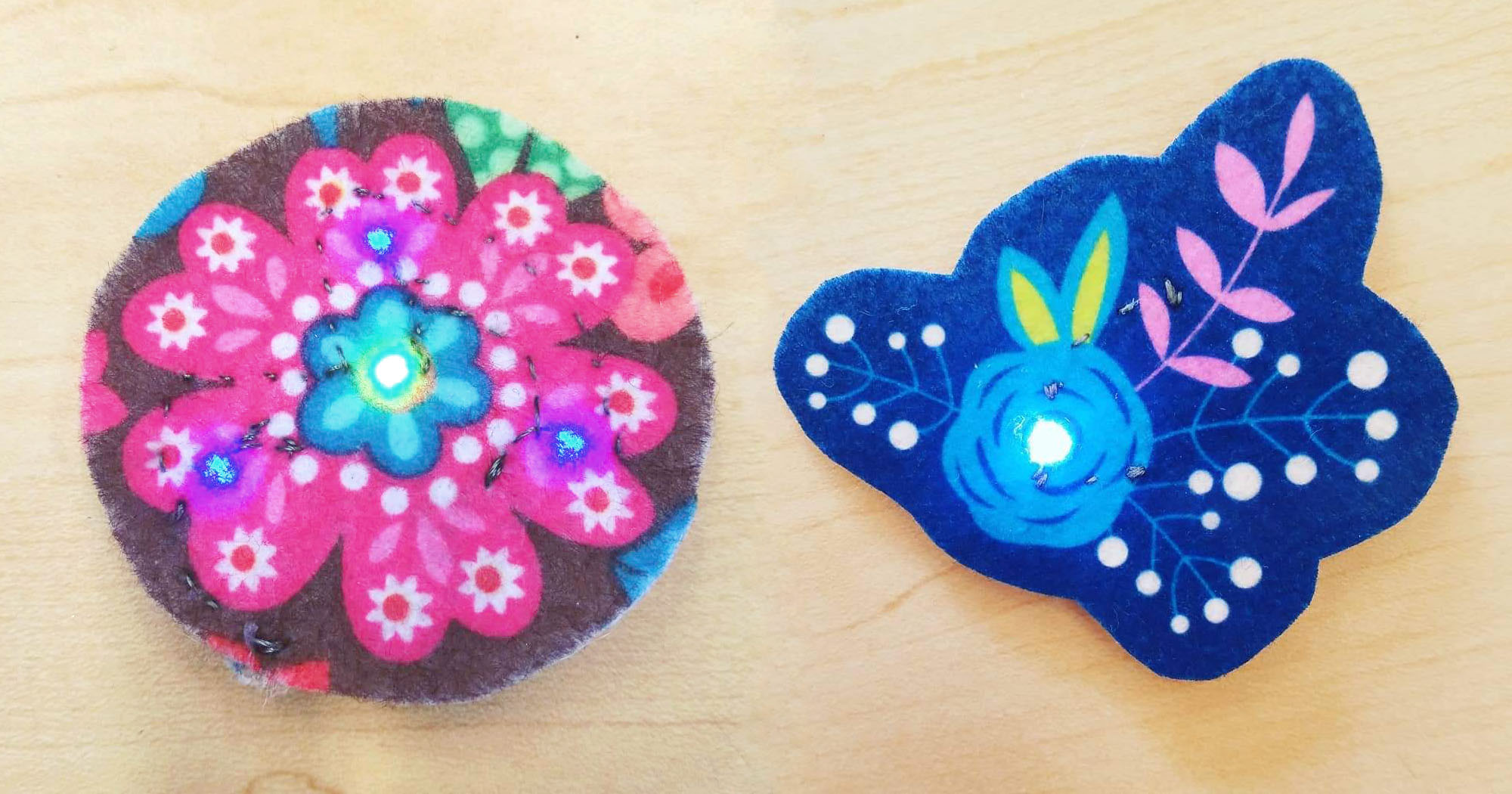 Colorful felt flowers with glowing centers made using conductive thread and LEDs
