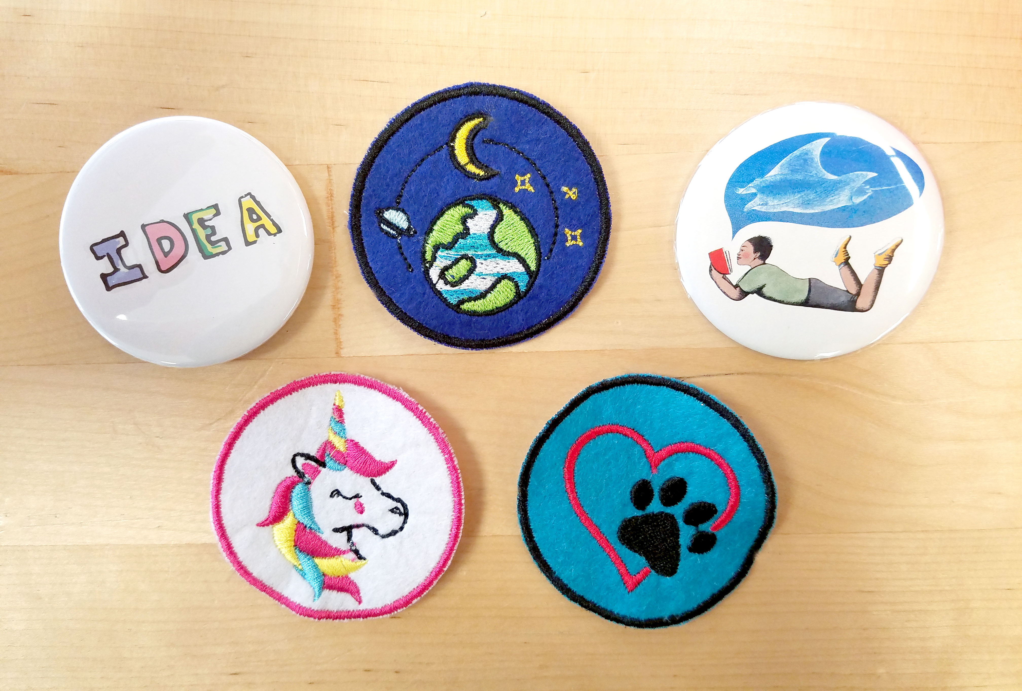 Embroidered patches and custom pins on a table