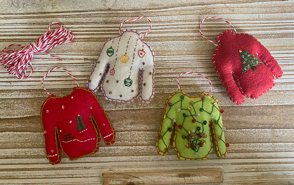 Hand embroidered wool felt ornaments in red, white, and green holiday colors