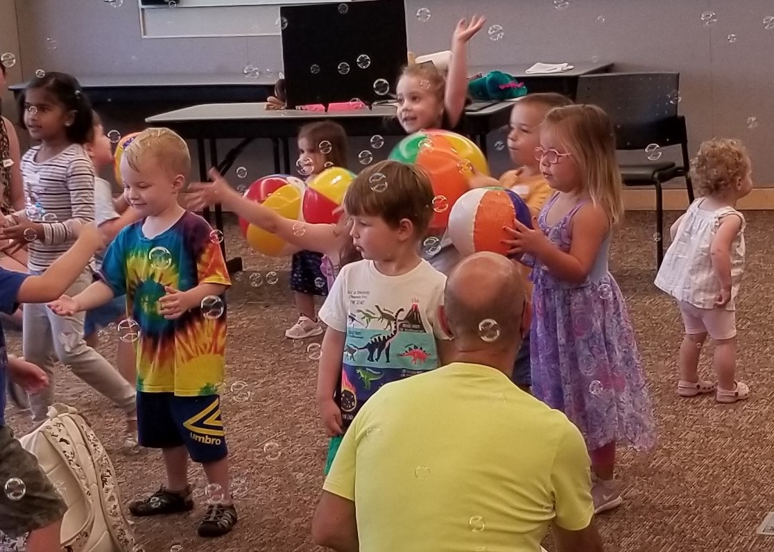 Kids playing with bubbles and beach balls in Storytime