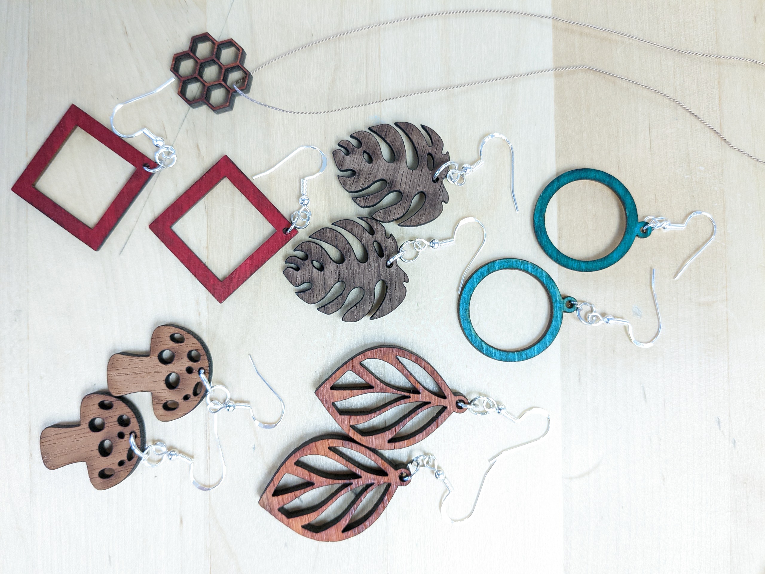 Various cut shapes from hardwoods on an earring wire