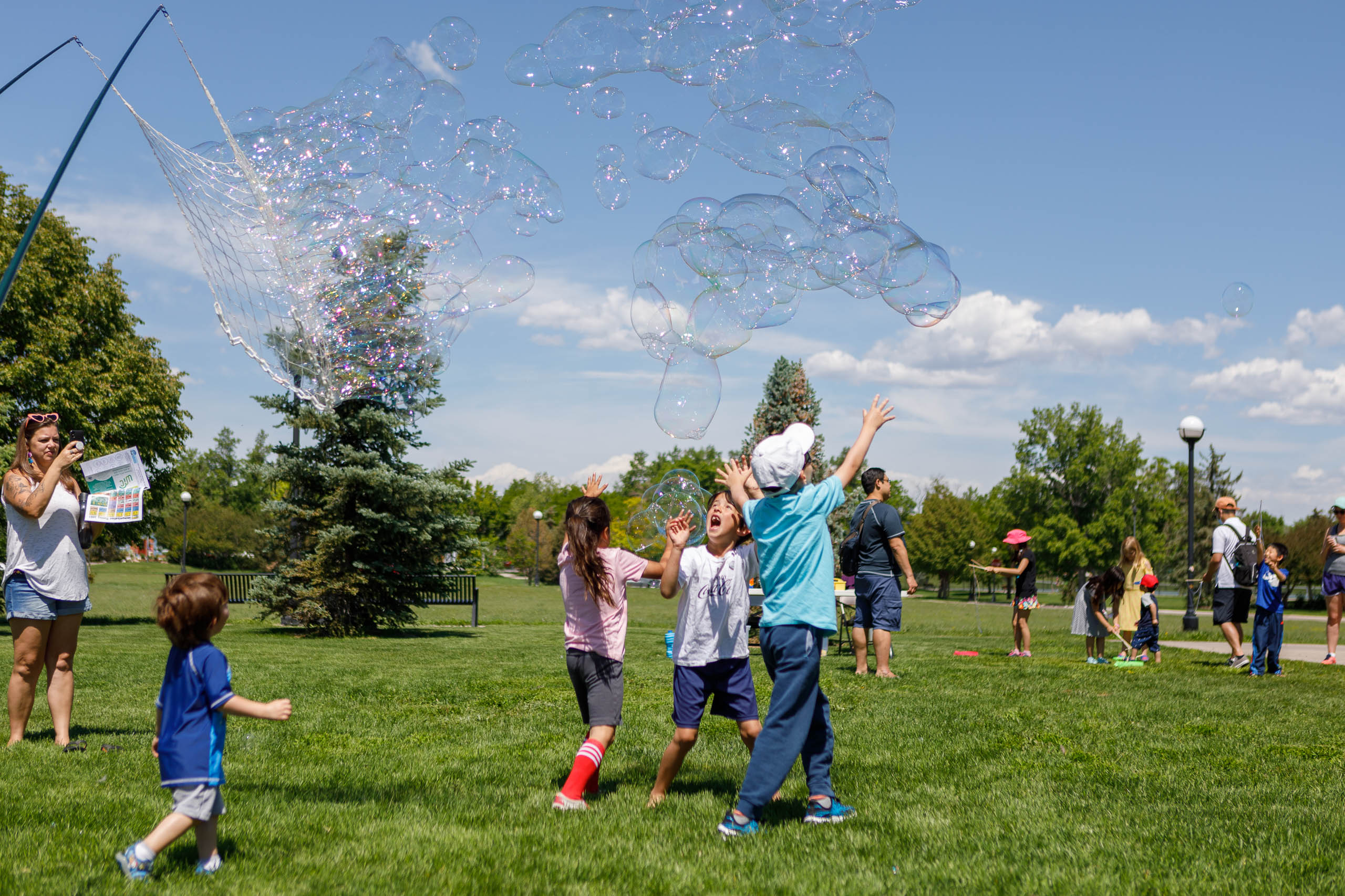 Kids play with giant bubbles outside