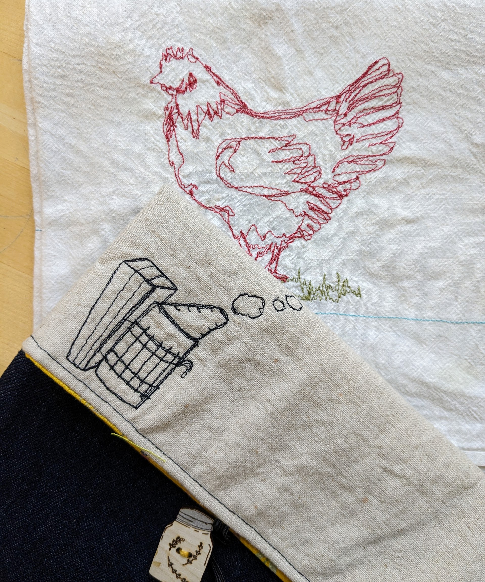 Hen and bee smoker drawings stitched onto fabric with a sewing machine.