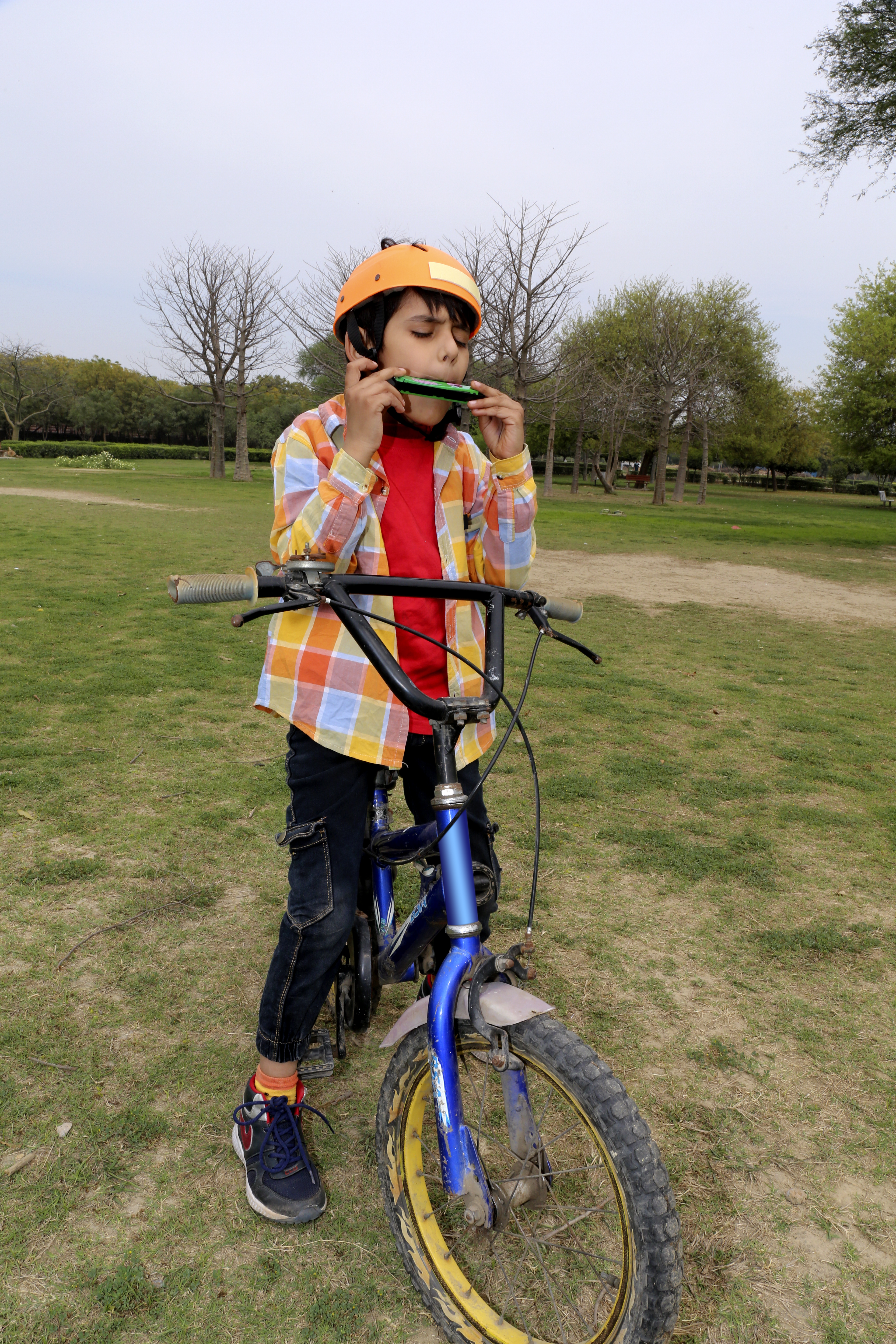 Boy on a bike playing the harmonica.