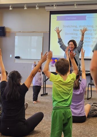 Librarian leading children in a storytime stretch