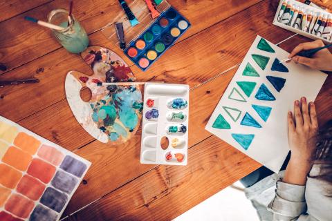 Overhead view of hands painting with watercolor paints