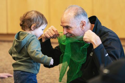 Caregiver and baby playing with scarf