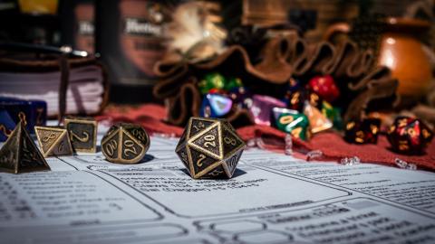 20-sided dice on dungeons and dragons character sheet all on a tabletop