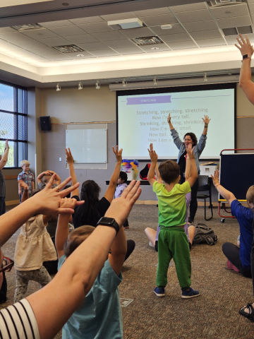 Librarian leading children in a storytime stretch