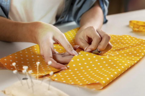 Close up of hands sewing with a needle and thread