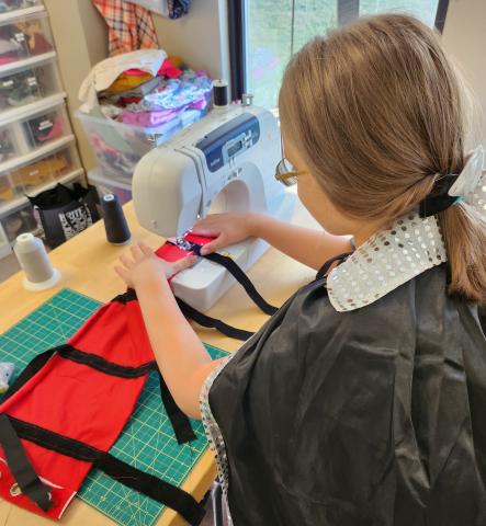 Person working on a Halloween costume using a sewing machine