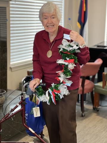 woman holding a garland made of tinsel and red, white and green cloth