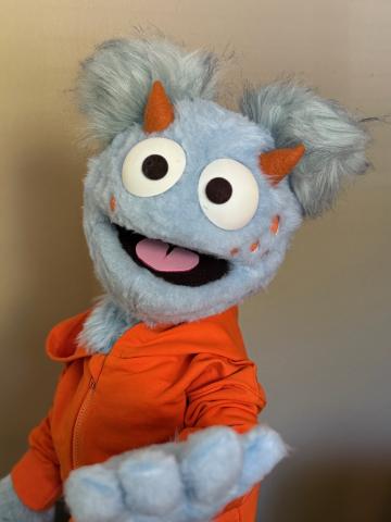 Blue puppet with red shirt.