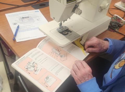 Close up of hands opening a sewing machine manual