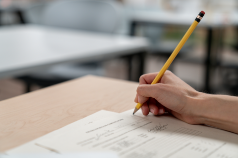 Closeup of a hand writing on an exam with a pencil