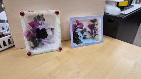 2 dioramas with purple plants and a mermaid.