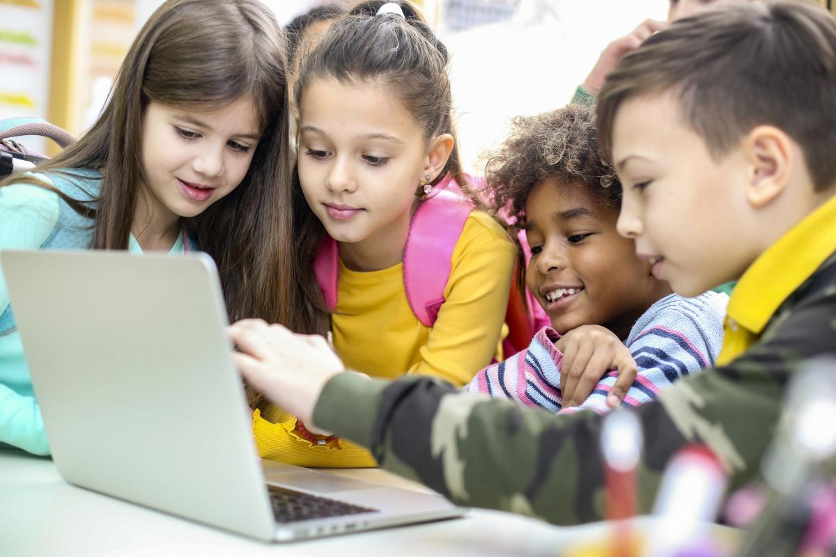 Group of four kids working on a laptop together