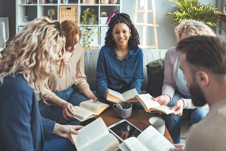 group of people reading books and talking