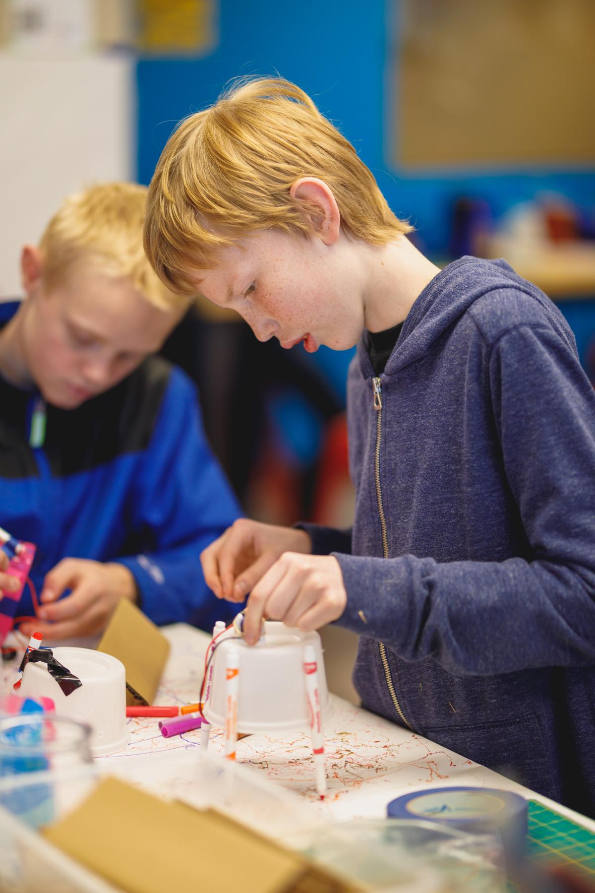 Tweens building robots out of recycled materials