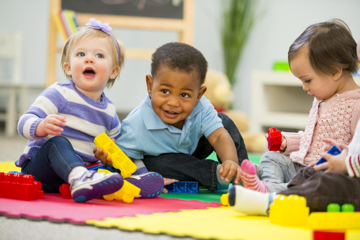 Babies and toddlers playing with colorful toys.