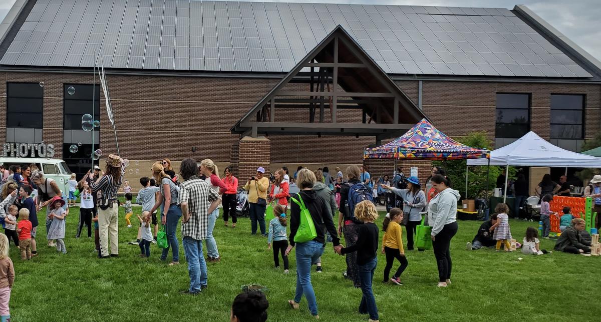 Kids chasing bubbles and play games on the library lawn