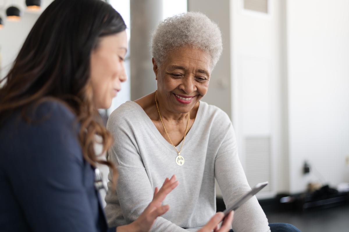 Two women talking while holding personal device.