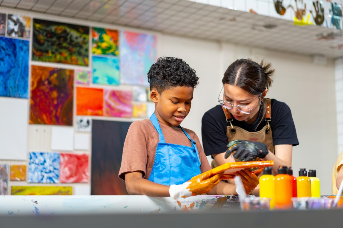 Student and teacher working on an art project.