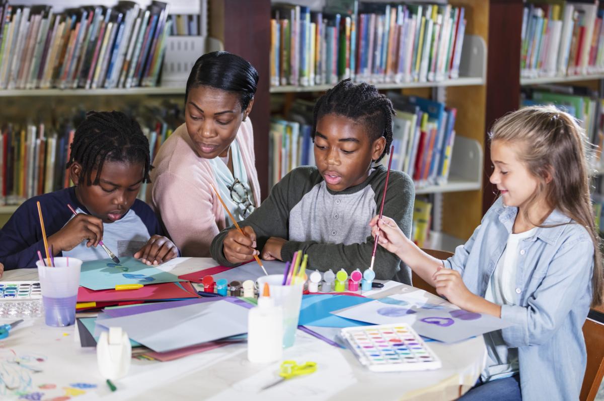 Tweens doing crafts at a library table.