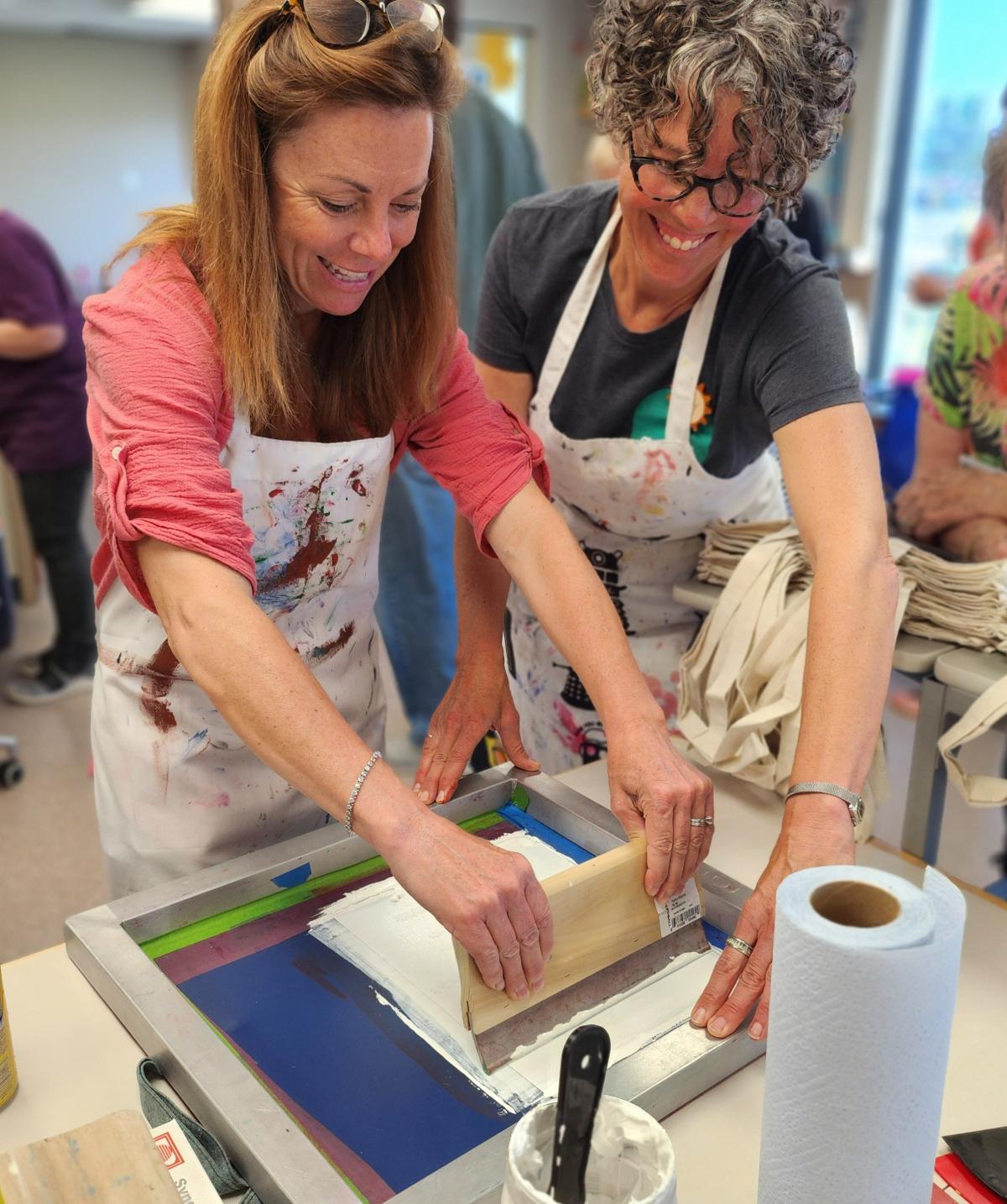 Two people working together to screen print