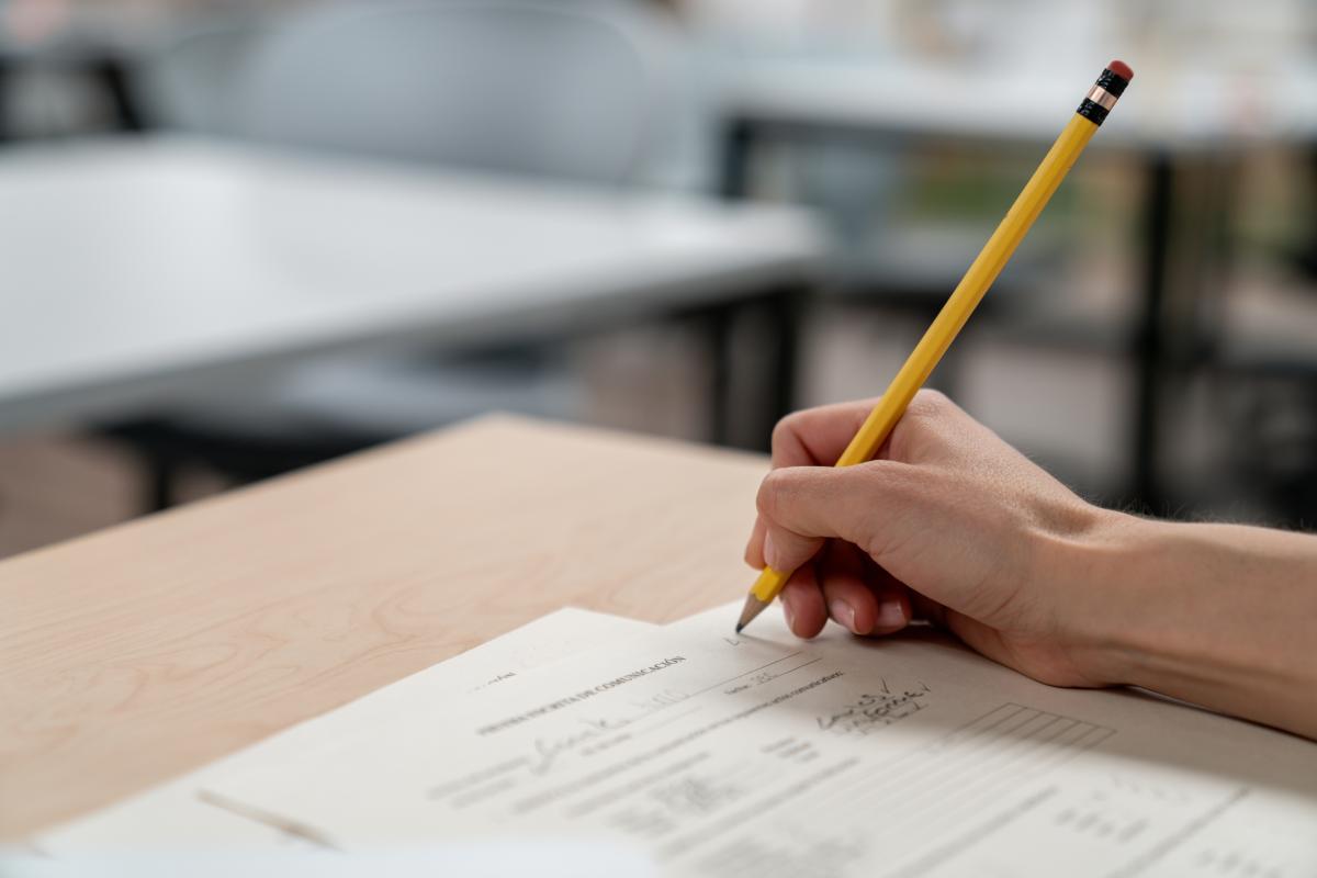 Closeup of a hand writing on an exam with a pencil