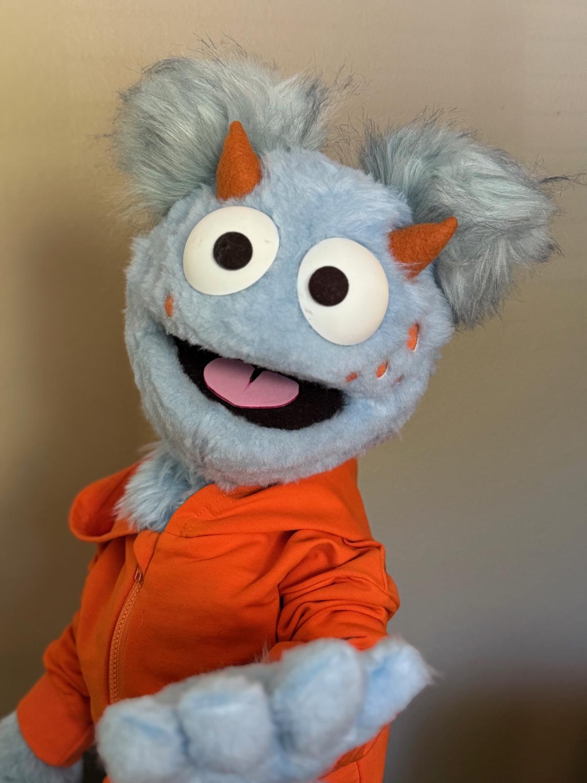 Blue puppet with red shirt.